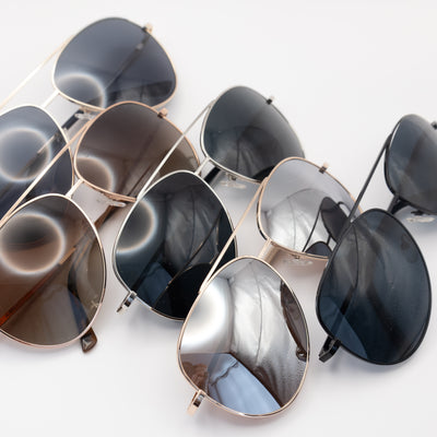 Five aviator sunglasses in various colours - top view.